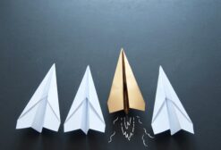 Gold paper plane standing out in a line