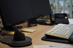 Schreibtisch mit Tastatur, Monitor und Computermaus