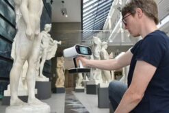 Person scannt mit einem Handscanner eine Skulptur im 3D-Scan.