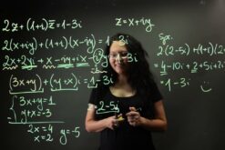 Frau steht am Learning Glass und schreibt Formeln.