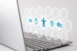 Laptop mit Hologramm mit Icons zu Hörassistenz, motorischen Einschränkungen und Sehbehinderung