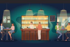 Bar mit Hockern, an denen Studierende mit Büchern, Kaffee und Laptop sitzen.