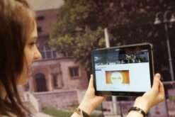 Frau betrachtet ein Tablet mit der Startseite der Moodle E-Learning-Plattform.